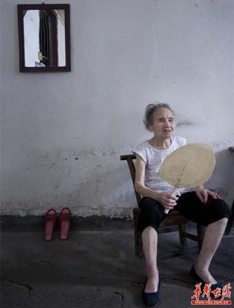 　90歲的王仲蓮如今已患有間歇性的老年癡呆，時而清醒、時而糊涂。圖為王仲蓮老人靜坐在屋內(nèi)，搖著蒲扇。