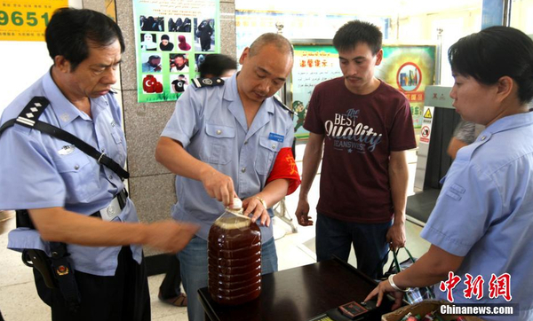 資料圖：7月29日，公安民警和安保人員正在克拉瑪依客運(yùn)站進(jìn)站口嚴(yán)查進(jìn)站旅客行李和違禁物品。 周建玲 攝