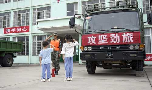 圖為在學(xué)校宿營點，小學(xué)生向抗洪官兵官兵敬禮表達(dá)謝意的畫面。（付少旋）